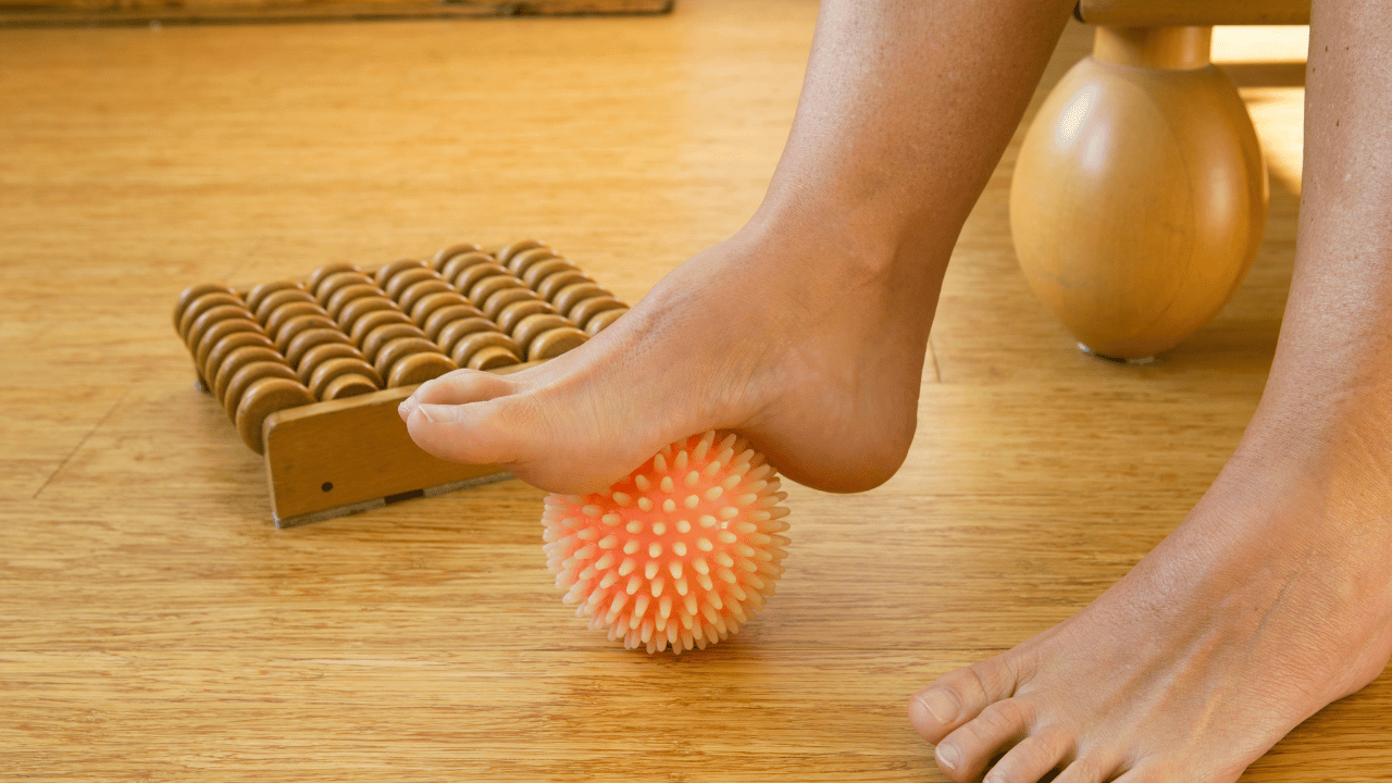 Auto massage plantaire à l'aide d'une balle de massage avec pics